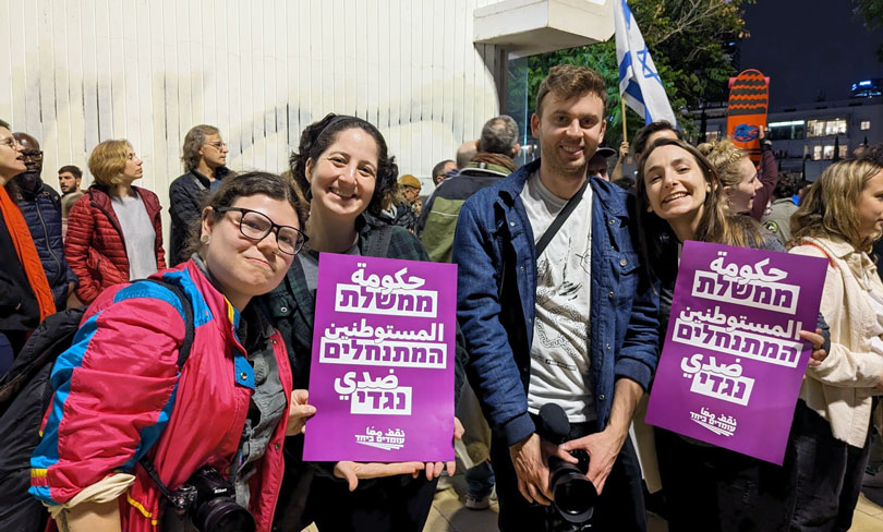 Participants from NIF’s Naomi Chazan Global Activism Fellowship are pictured with Omdim Beyachad signs that read “The settler government is against me.”