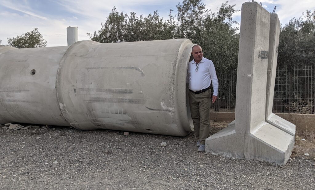 A man stands next to temporary bomb shelters in the Negev