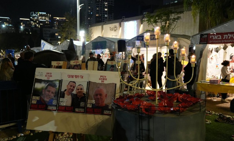 Hostage posters next to a lit menorah