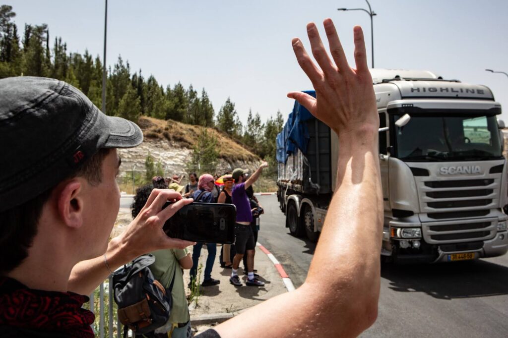 Humanitarian guard volunteers encourage aid truck drivers as they leave safely