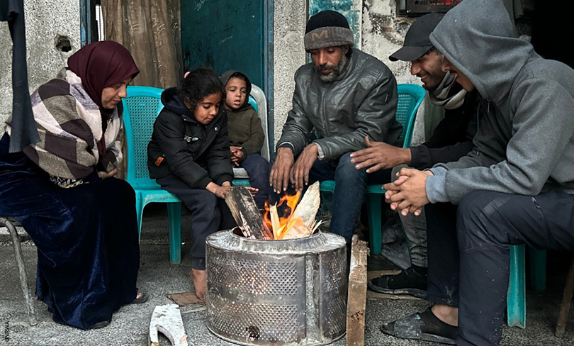 Palestinians in Gaza gather around a fire