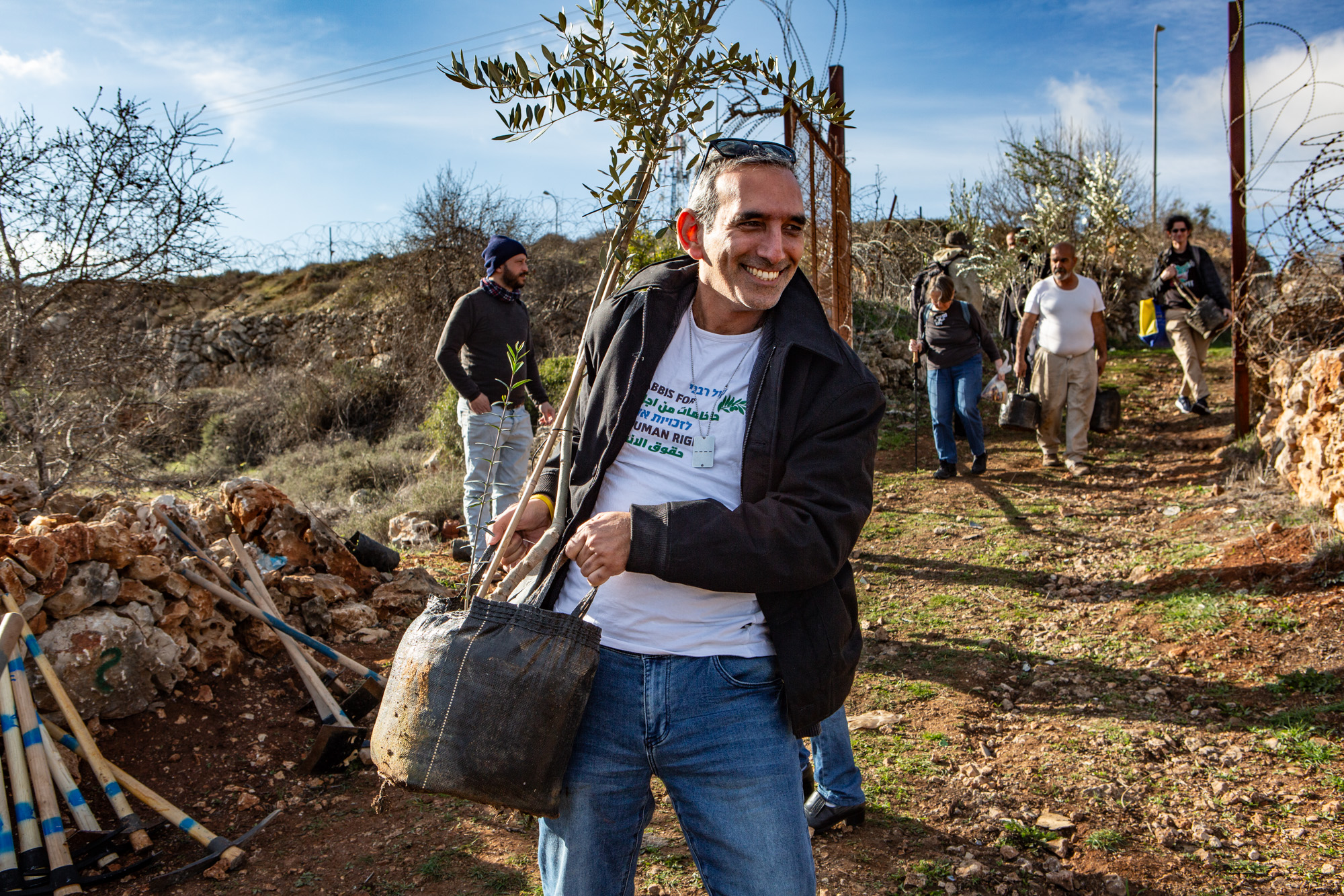 Rabbi Avi Dabush of Rabbis for Human Rights carries a sapling