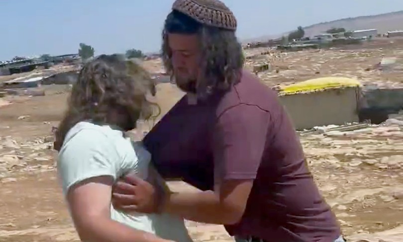 A settler shoves a Rabbis for Human Rights volunteer