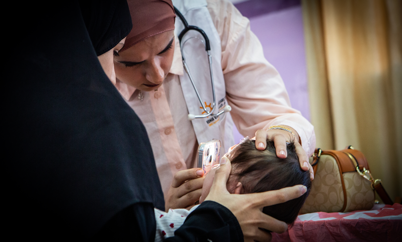Doctors examine a child at a PHRI mobile clinic in the West Bank